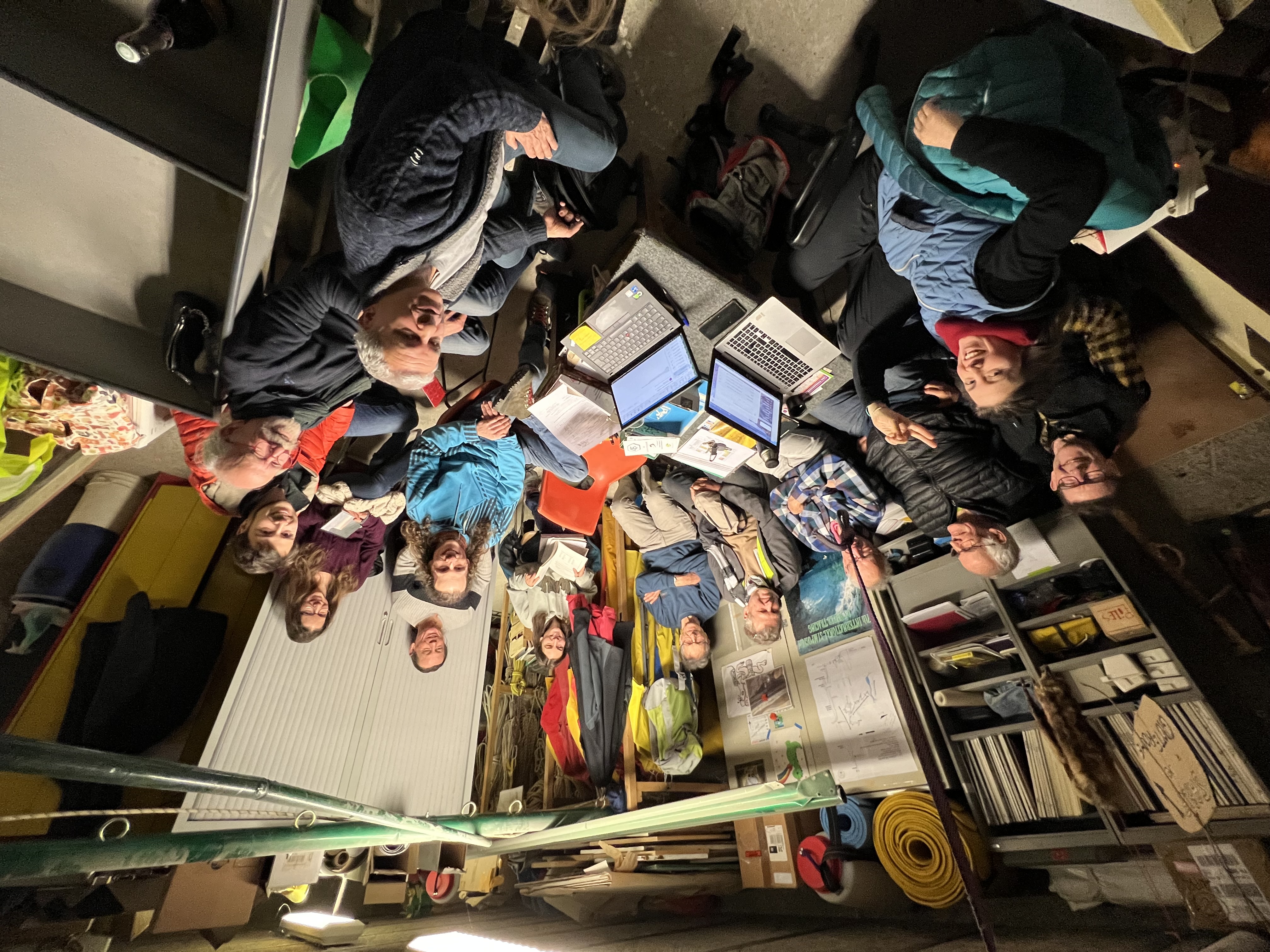 Club spéléologie Grenoble - Groupe de membres du club de spéléologie en réunion, entourés de matériel, photo par Eva Lourau